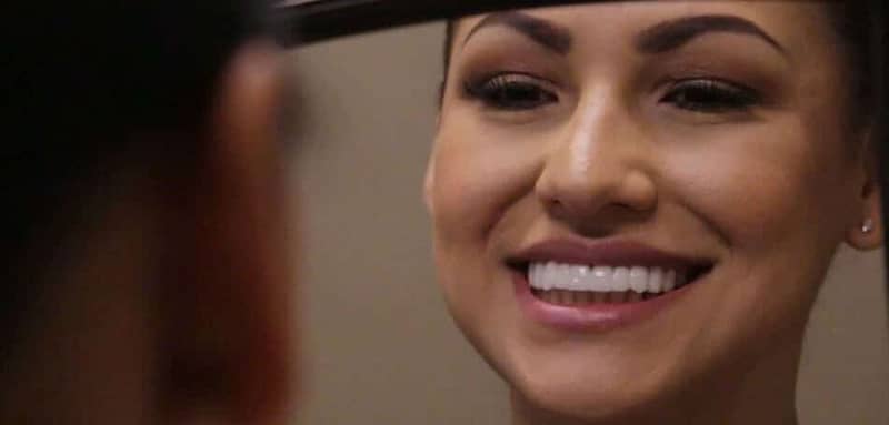 Maria looks at her new BIL Veneers in the mirror